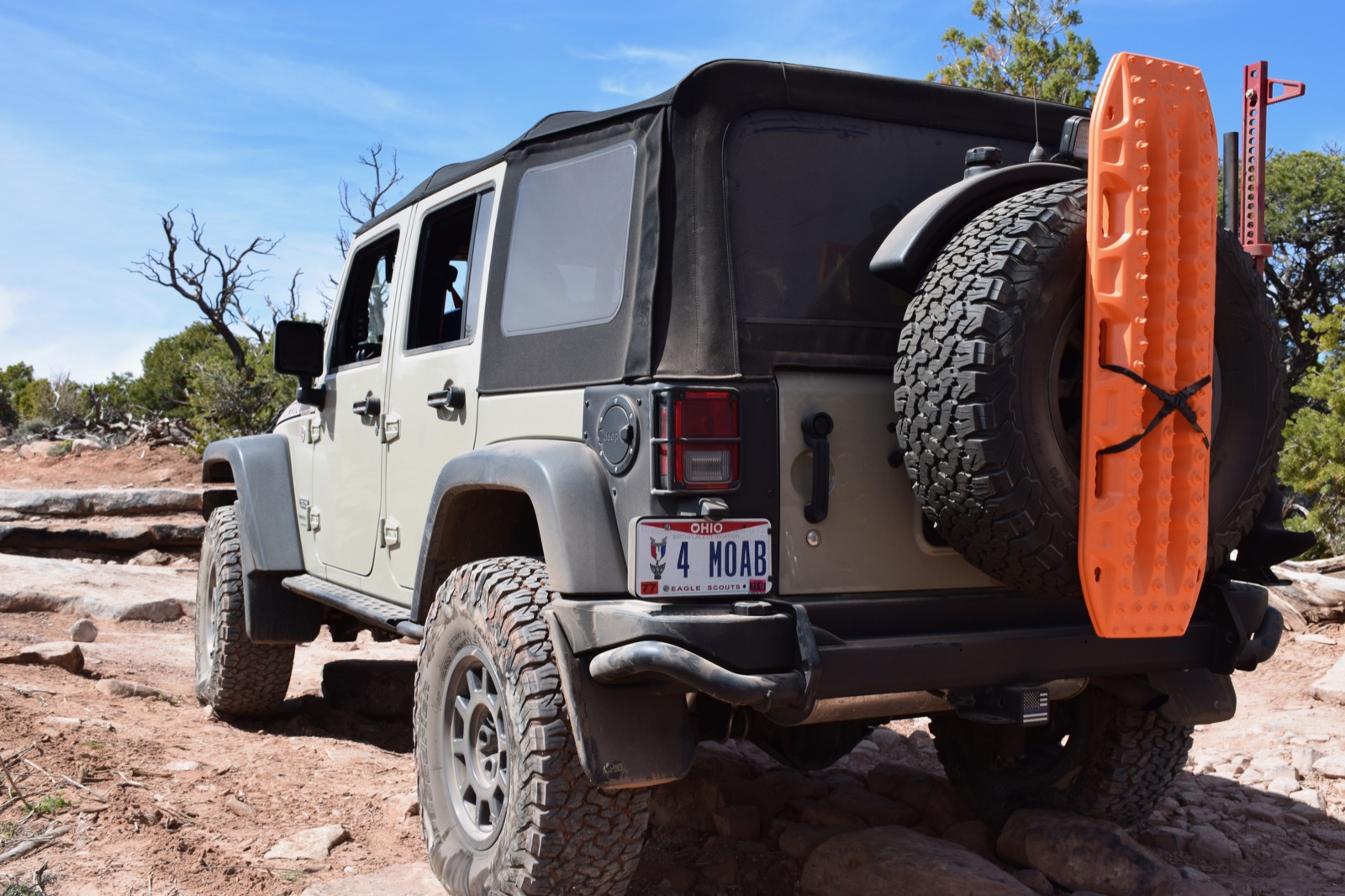 Rear view of the Wrangler showing its AEV tire carrier and orange traction board